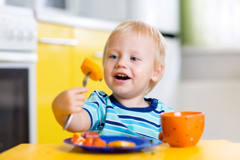 niño autónomo comiendo solo con un tenedor