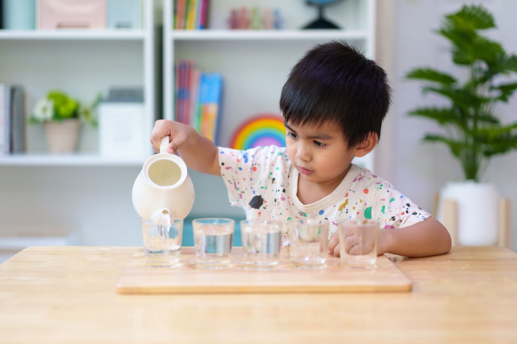niño haciendo trabajo de manipulación de jarra, tendencia humana Montessori