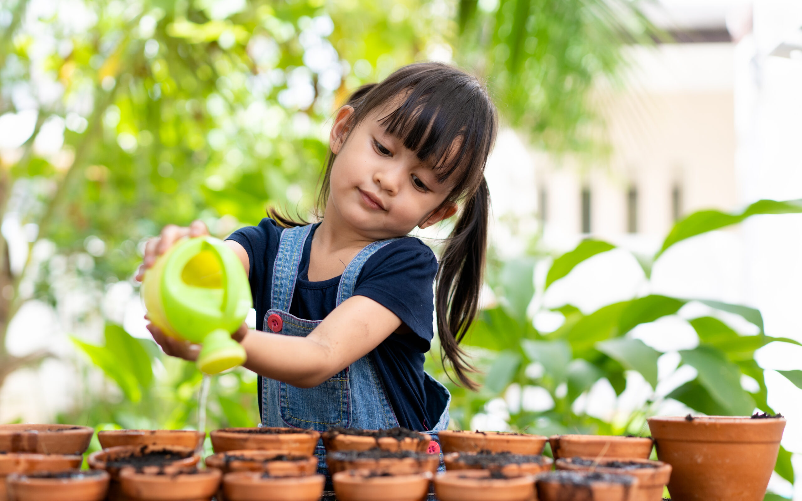 niña regando plantas como símbolo de autonomía., uno de los 10 consejos montessori para padres y madres