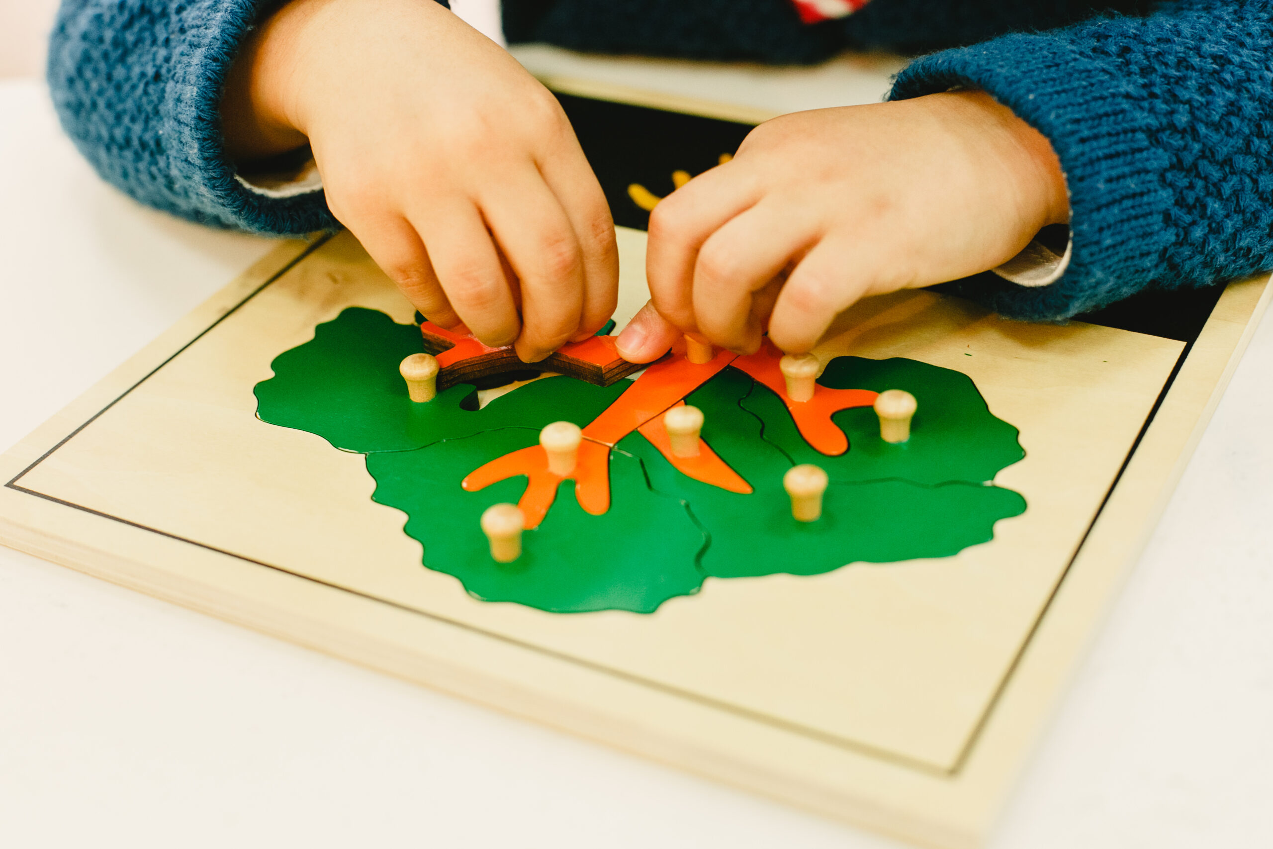 niño manipulando material montessori y experimentando