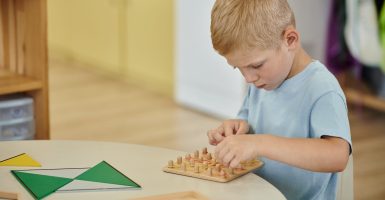Niño concentrado trabajando con material Montessori en ambiente preparado