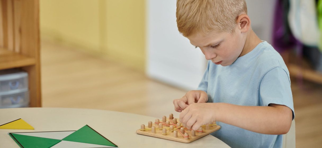 Niño concentrado trabajando con material Montessori en ambiente preparado