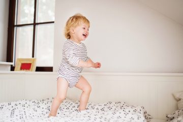 cute toddler boy jumping on the bed pzhqdby