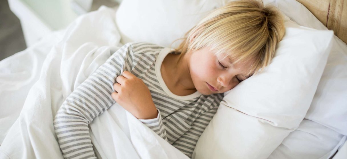 Boy sleeping on bed in the bedroom at home