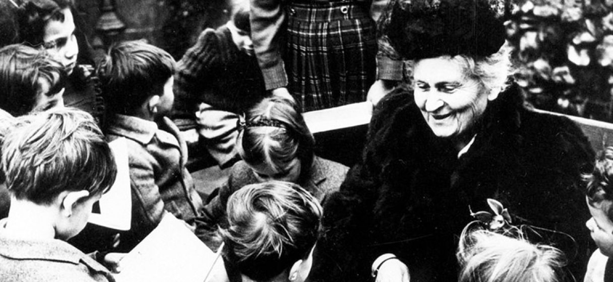 maria montessori rodeada de niños