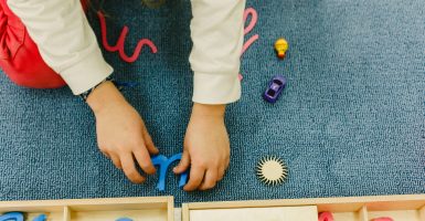 niña usando materiales para trabajar el área del lenguaje con montessori