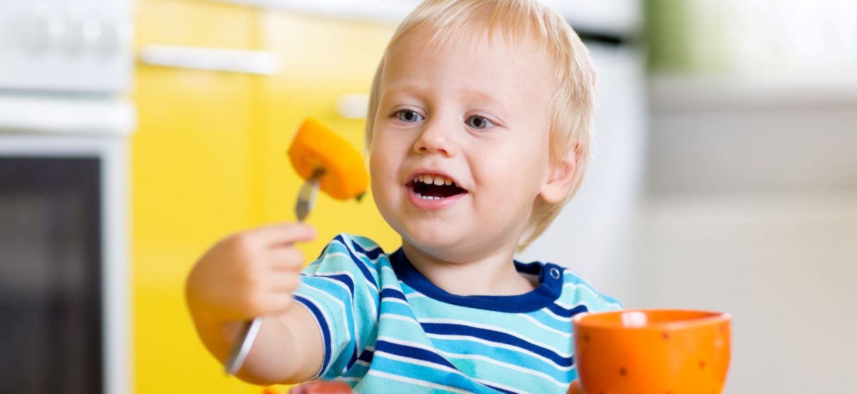 niño autónomo comiendo solo con un tenedor