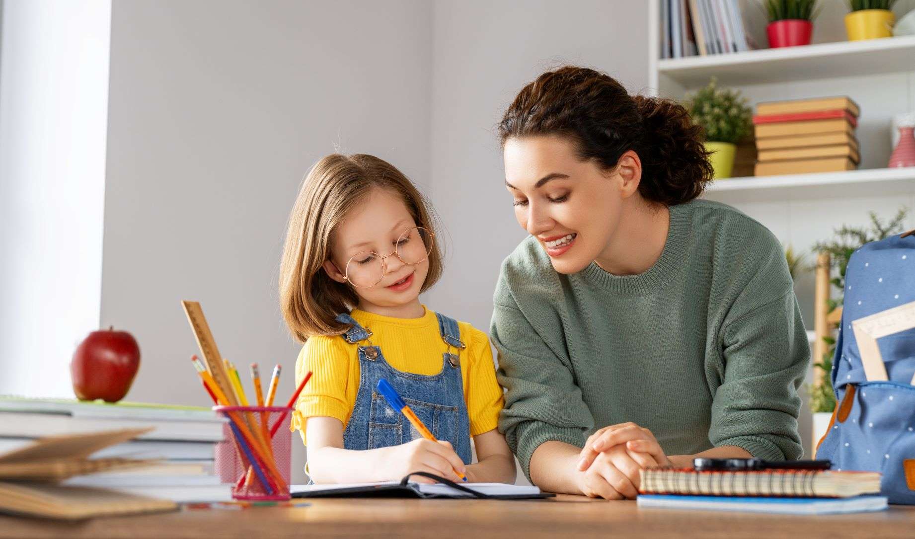 mama ayudando a su hija a hacer los deberes escolares
