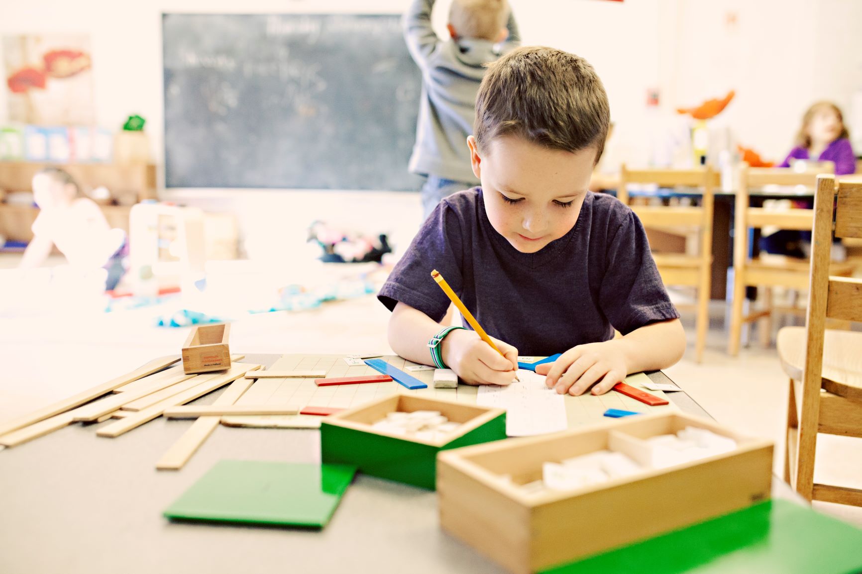 niño concentrado trabajando con material montessori de matematicas