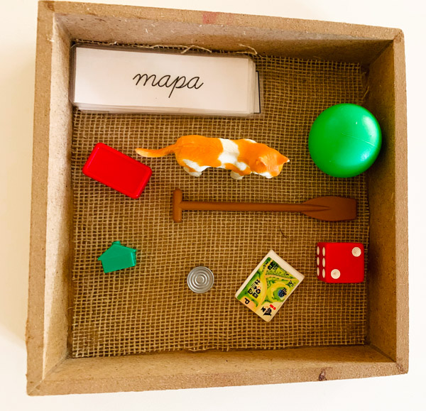 Objetos y tarjetas con nombres dentro de caja