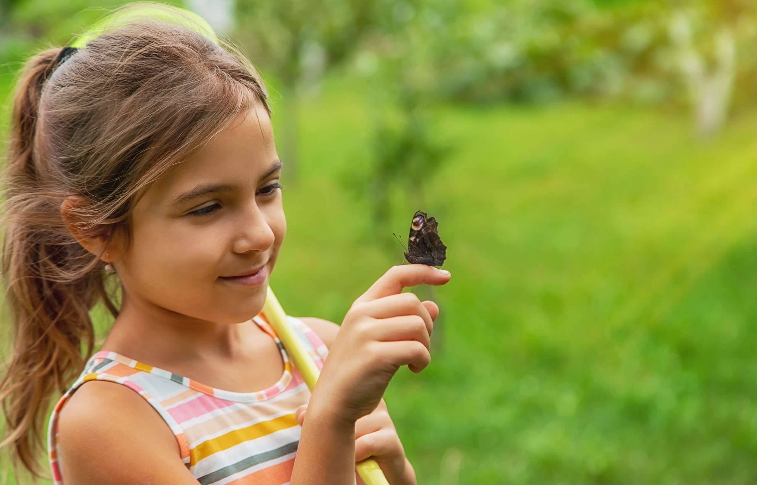 Educacion cósmica. Niña observando una mariposa
